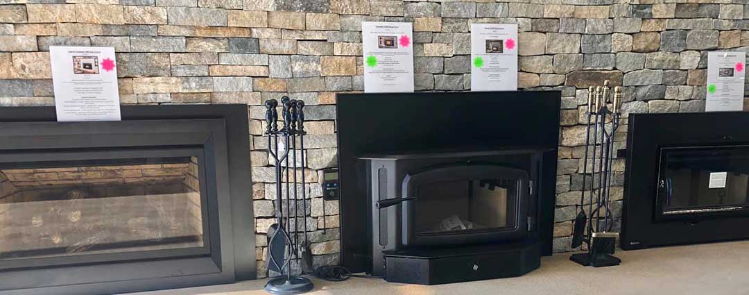 Fireplace showroom with three new wood fireplaces with prices and tools shown